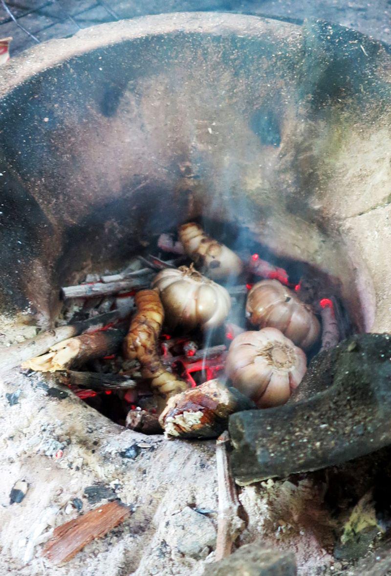 Photo 66 - Les gousses d’ail non encore épluché ainsi que le galanga dans la braise du fourneau